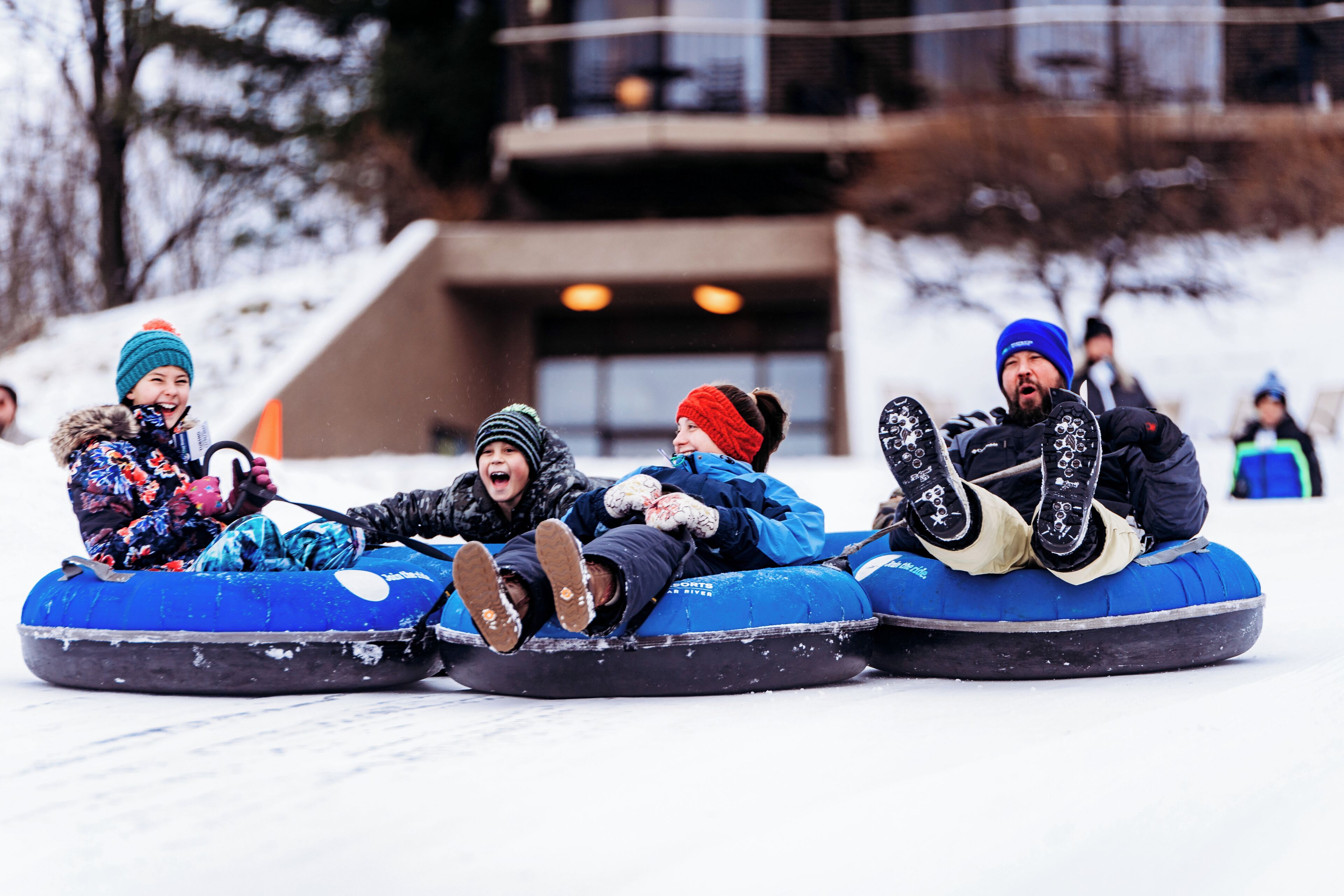 Un grupo de personas deslizándose en neumáticos de nieve.