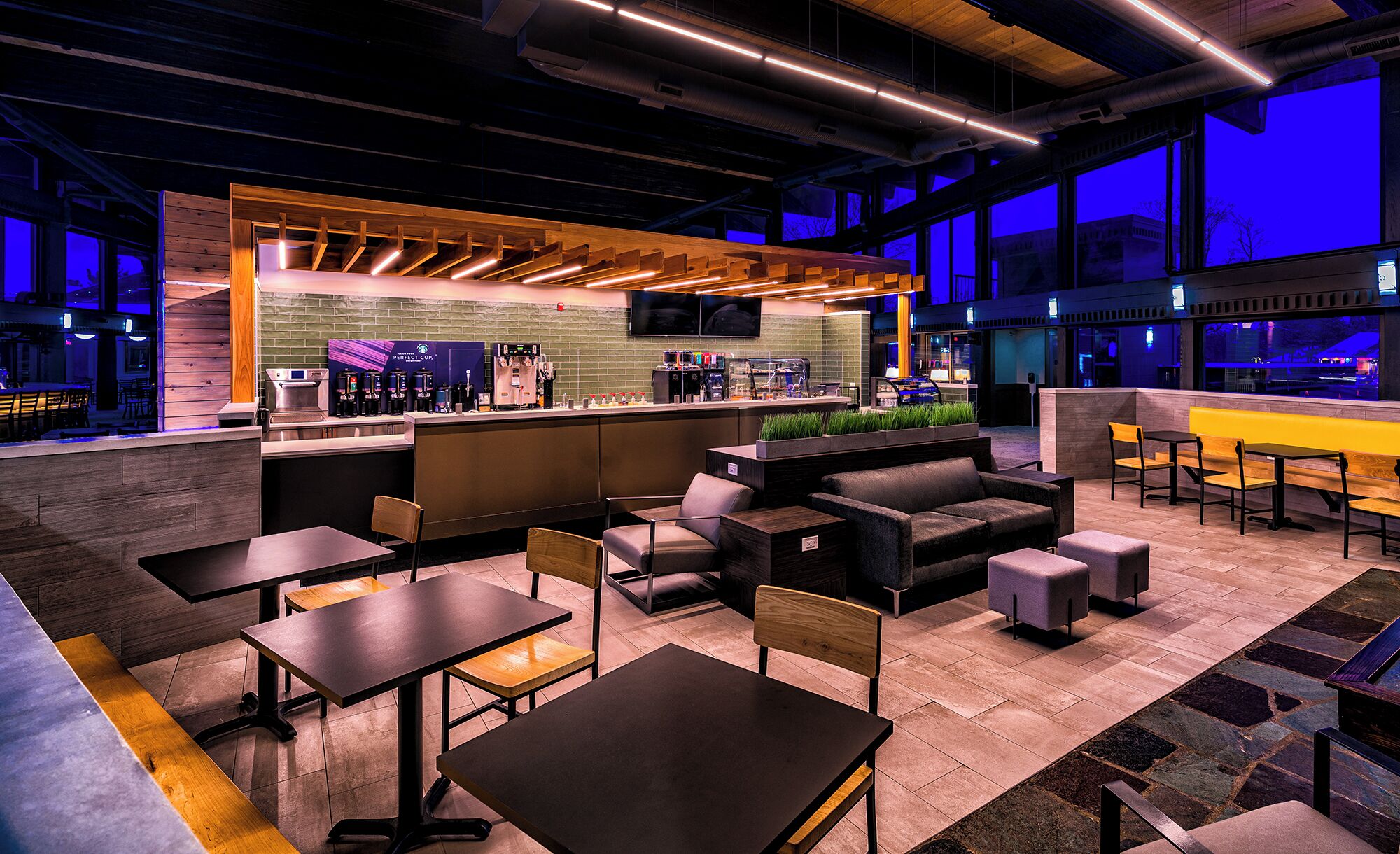A modern bar area with seating and a coffee machine.