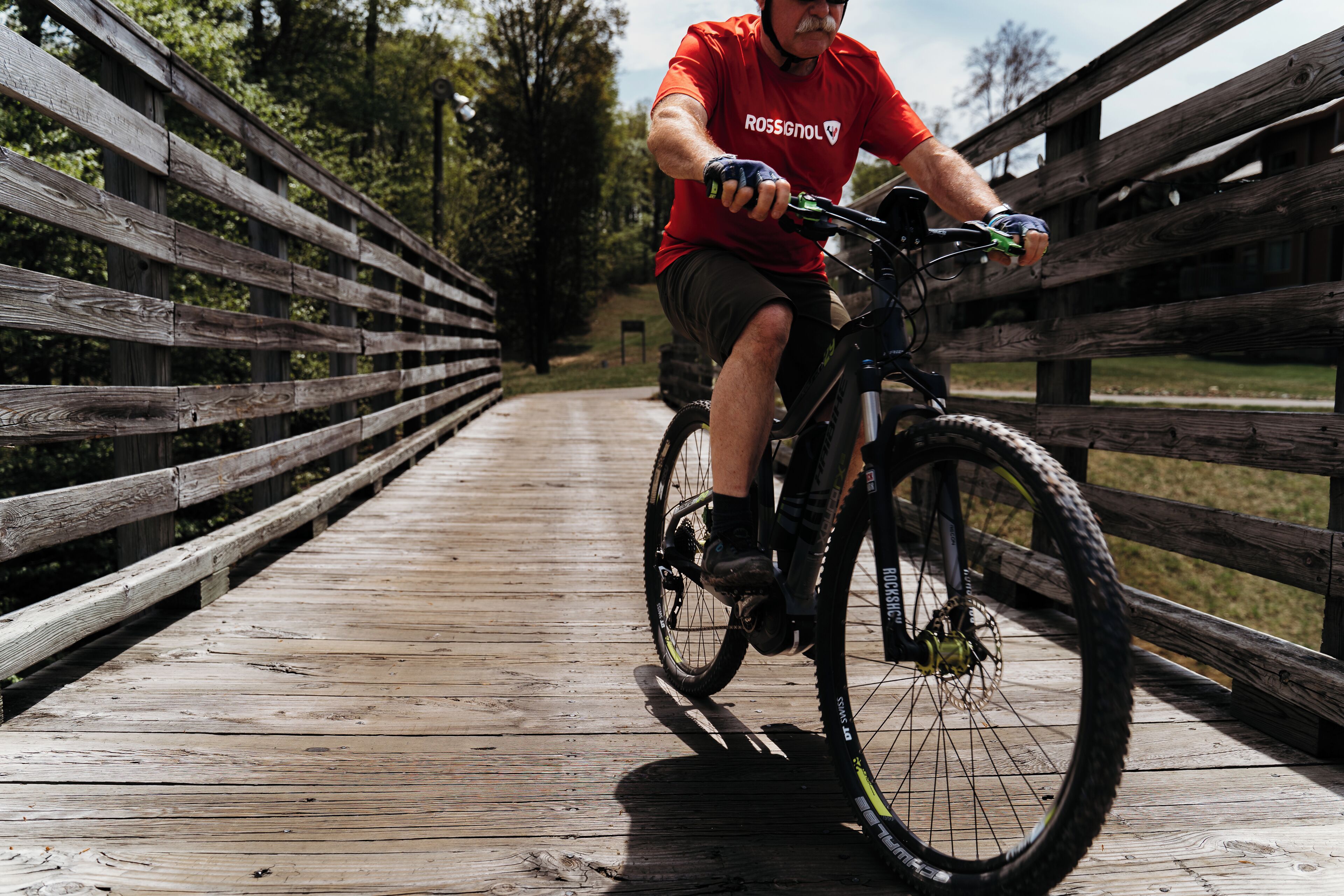 A person riding a bicycle on a wooden bridge.