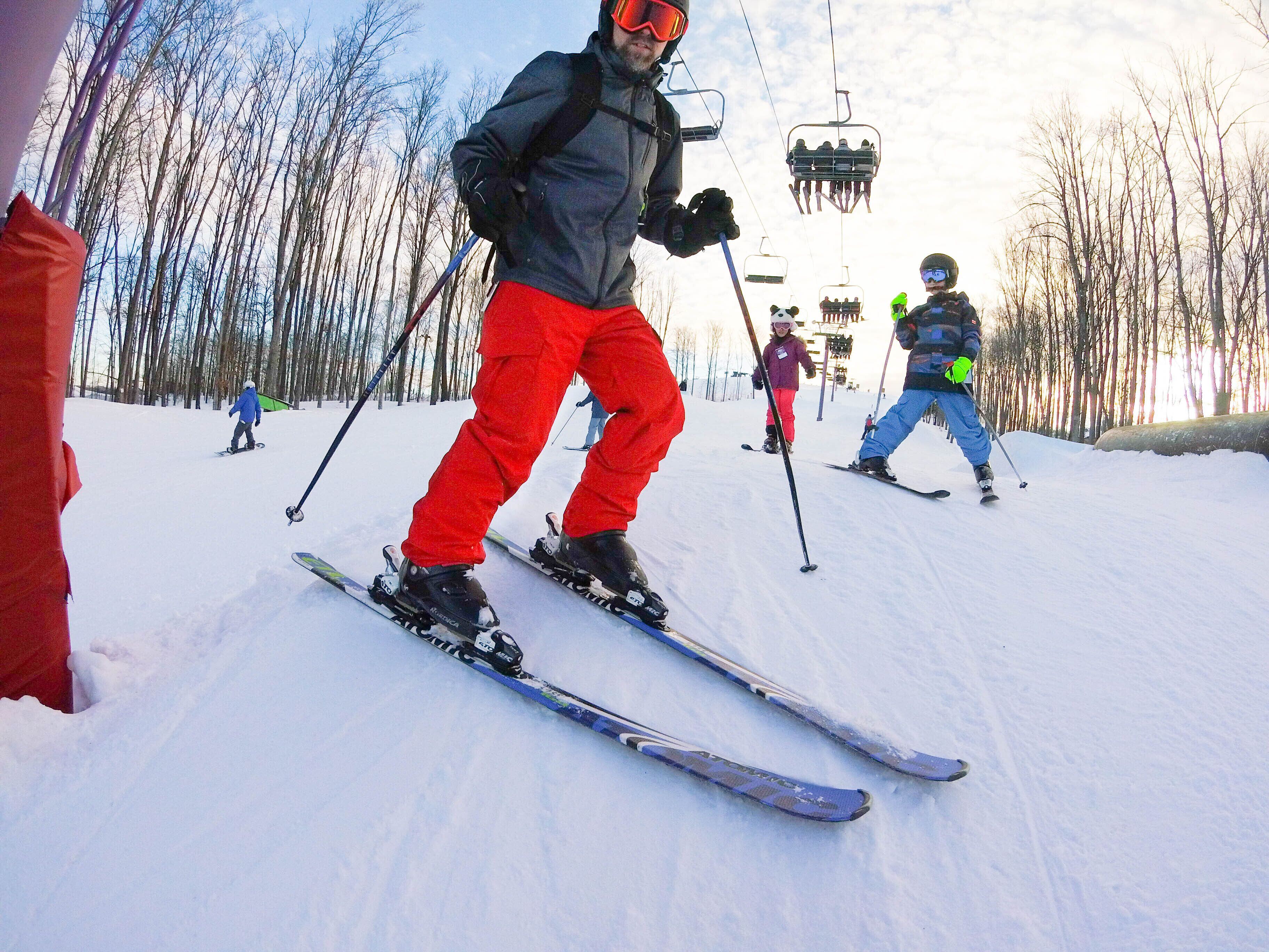 A person skiing on a snowy slope with trees in the background.