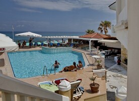 Una piscina al aire libre de temporada, sombrillas