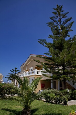 A hotel with a balcony, a palm tree, and a clear blue sky. - Jo-An Beach Hotel (Rethymno)