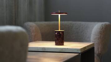 A modern table with a marble base and a minimalist lamp.