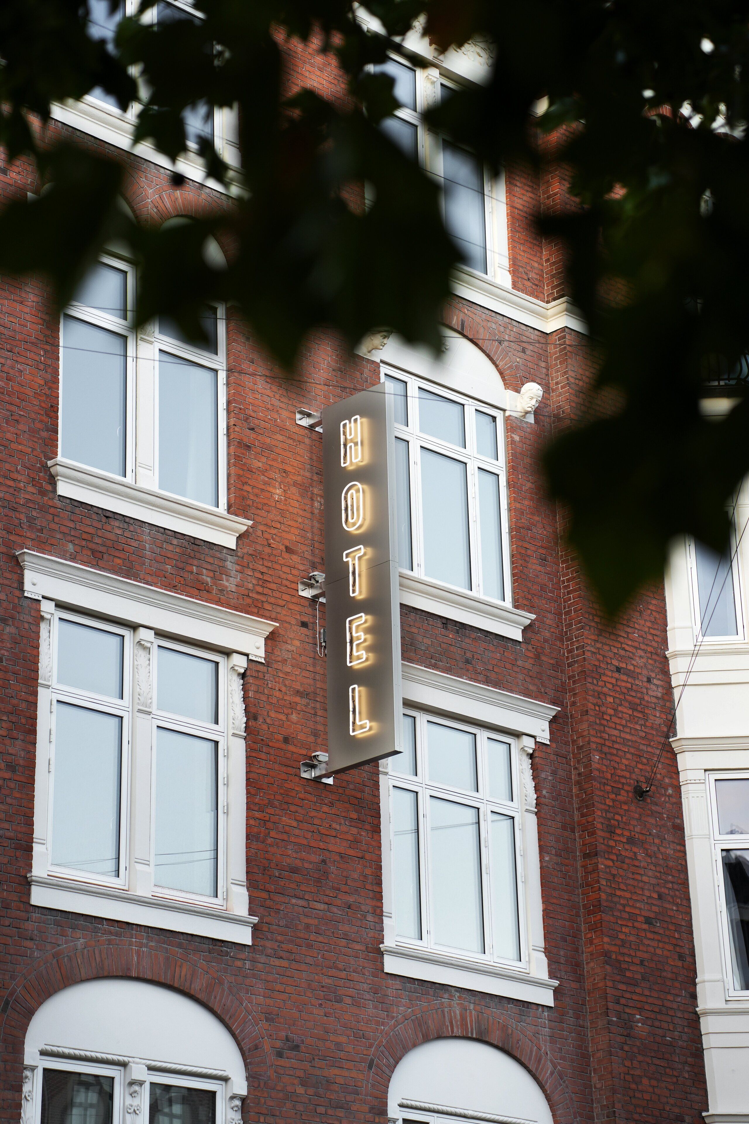 Une enseigne d’hôtel avec le mot « HÔTEL » inscrit sur une banderole verticale.