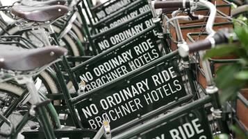 A row of bicycles with signs that read "NO ORDINARY RIDE BROCHNER HOTELS".