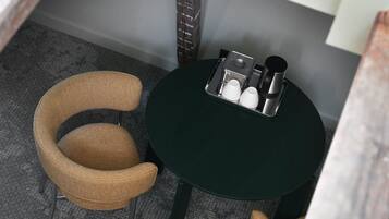 A small room with a round table, two chairs, and a coffee maker.