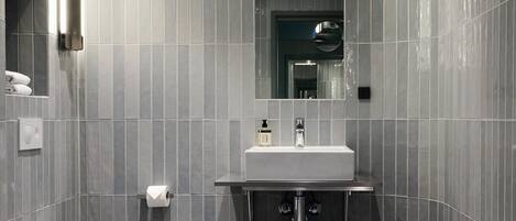 Un bagno moderno con un water, un lavandino e uno specchio.