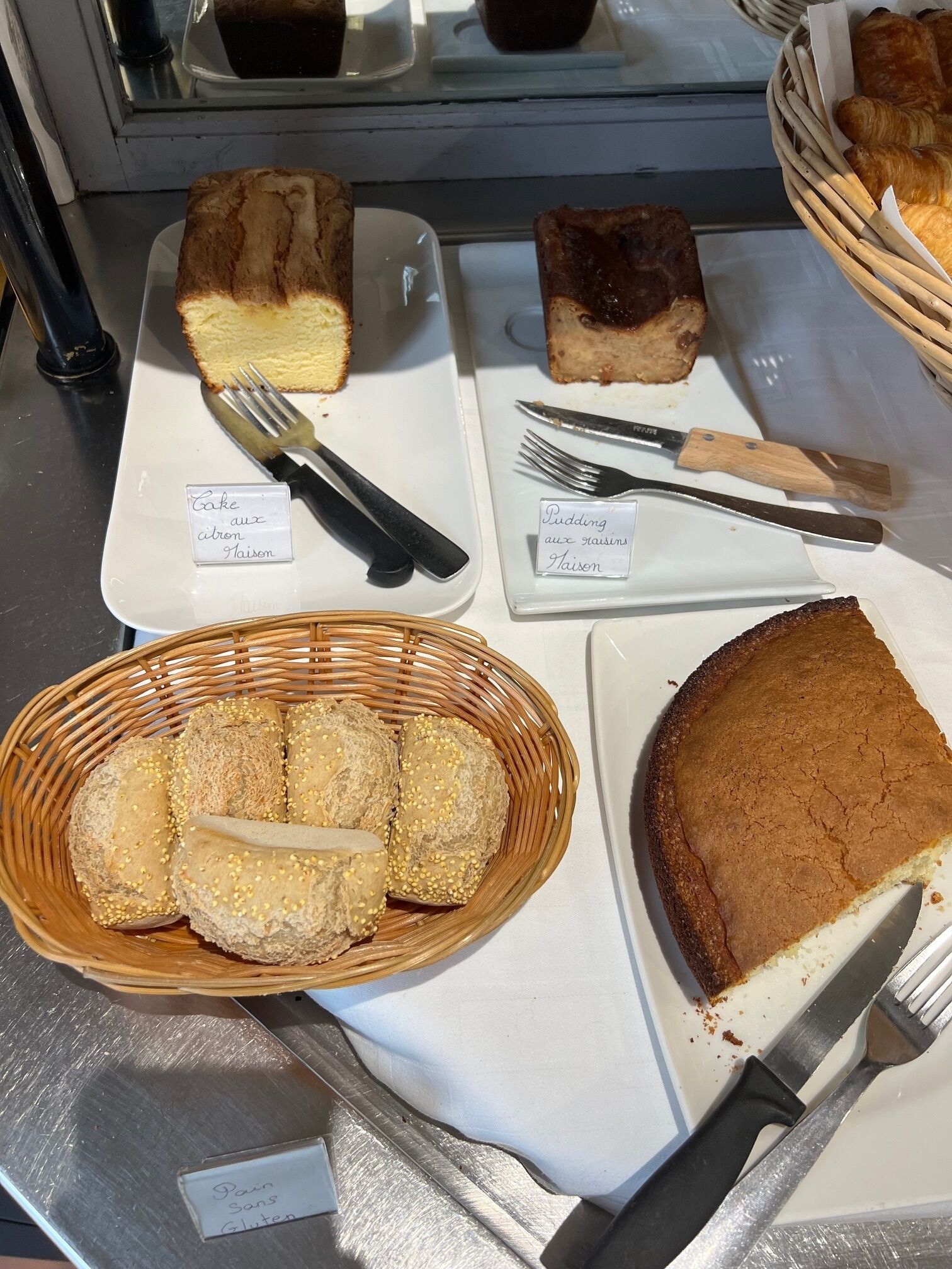 Exhibición de productos horneados, incluyendo pasteles, pan y repostería, cada uno con su tipo e ingredientes indicados.