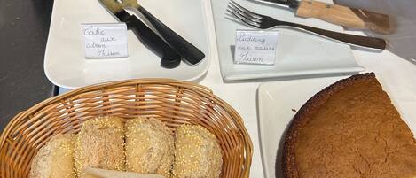 Exhibición de productos horneados, incluyendo pasteles, pan y repostería, cada uno con su tipo e ingredientes indicados.