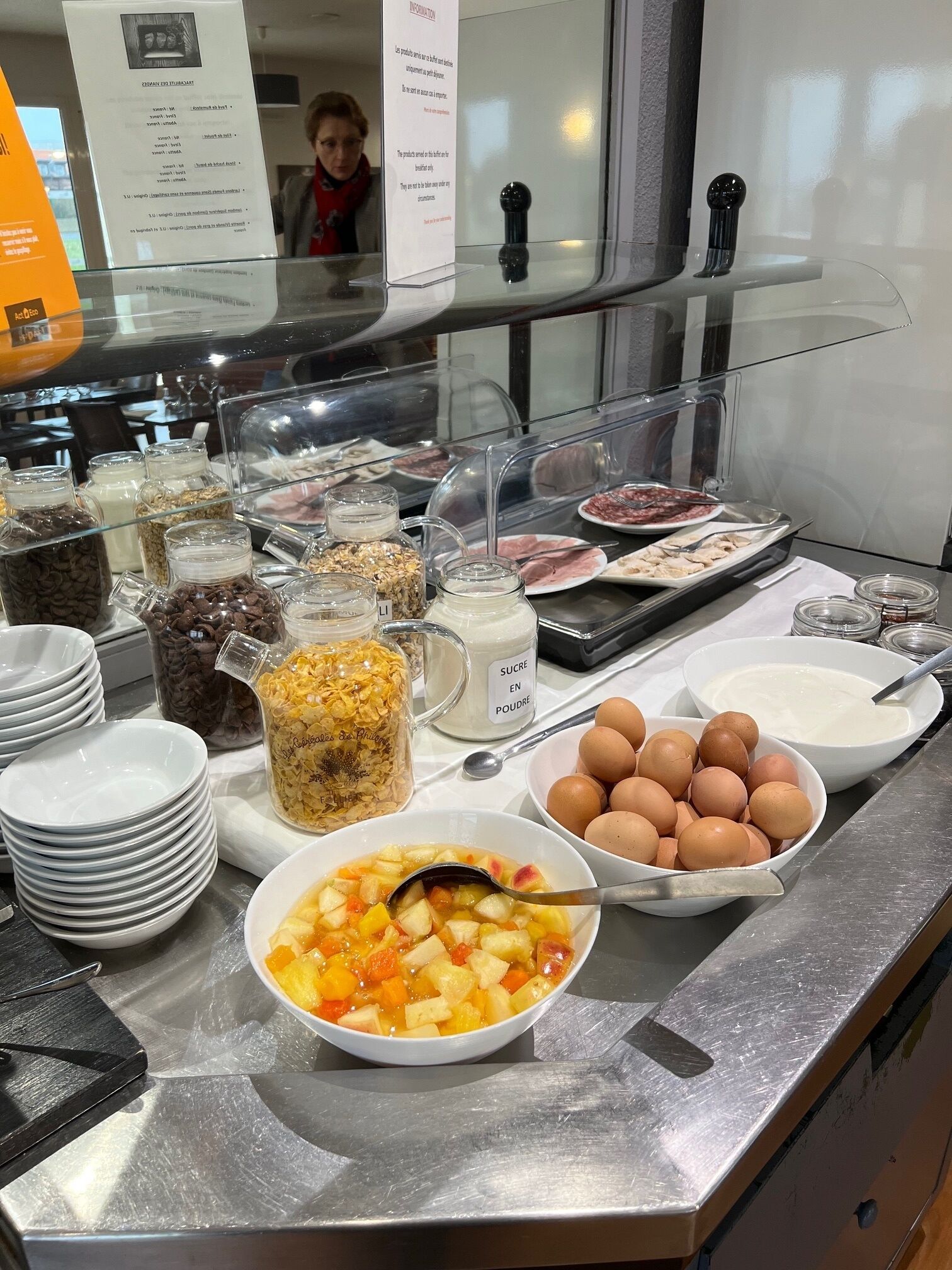 Een buffet met verschillende soorten eten, zoals fruit, ontbijtgranen en zuivelproducten.