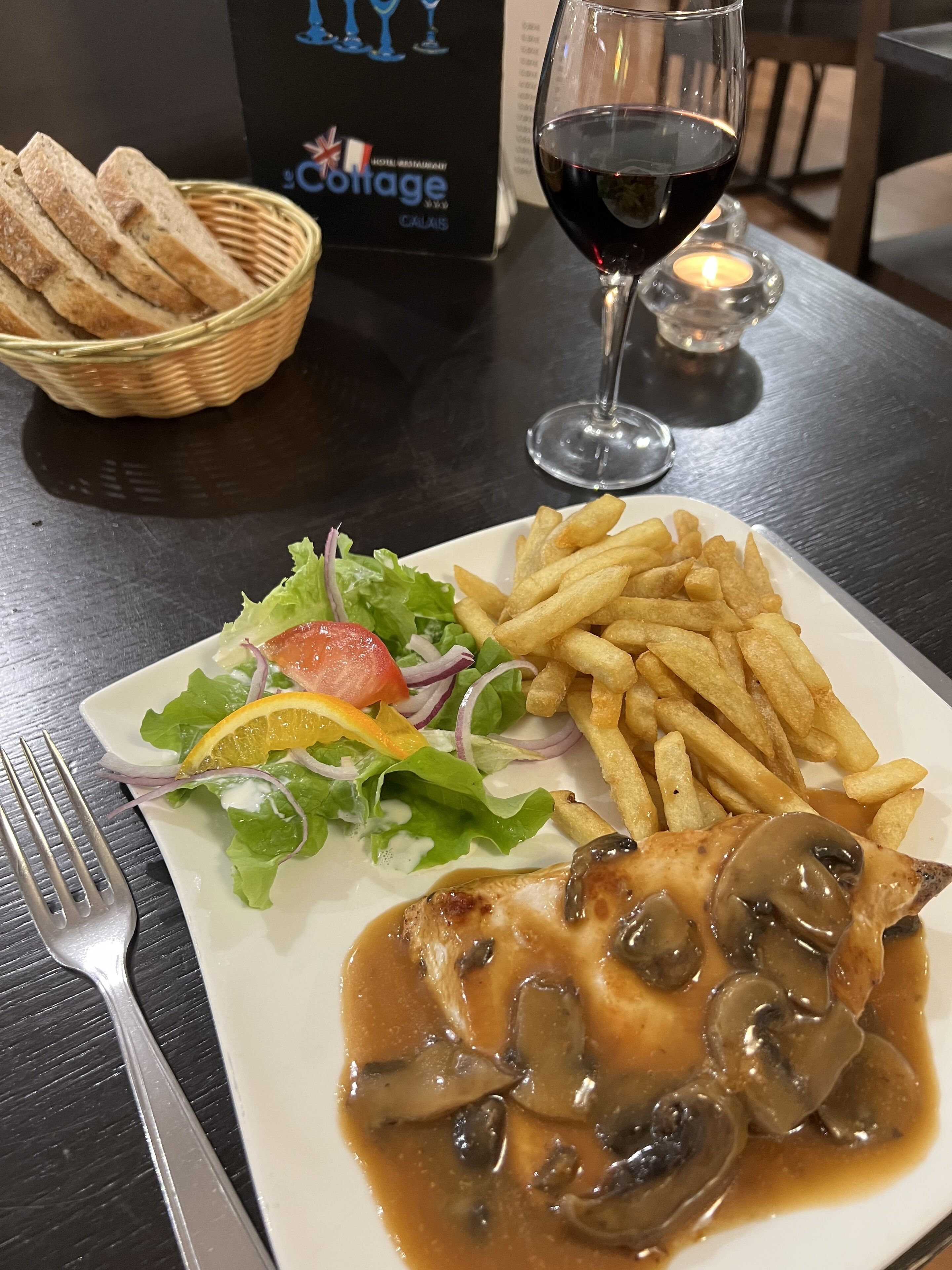 Un plato de comida con ensalada, papas fritas y un guiso de carne con champiñones.