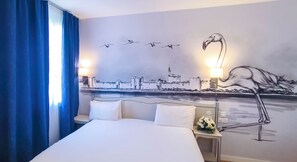 Relax in a stylish room with a large bed, cityscape mural, and bedside lamps.