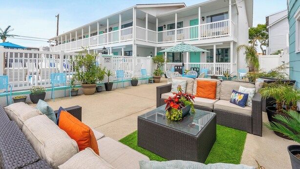 Un hôtel doté d’espaces extérieurs aménagés, de nombreux balcons et de plantes en pot.