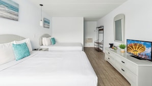 Une chambre d’hôtel avec deux lits, une télévision, un bureau et une fenêtre.