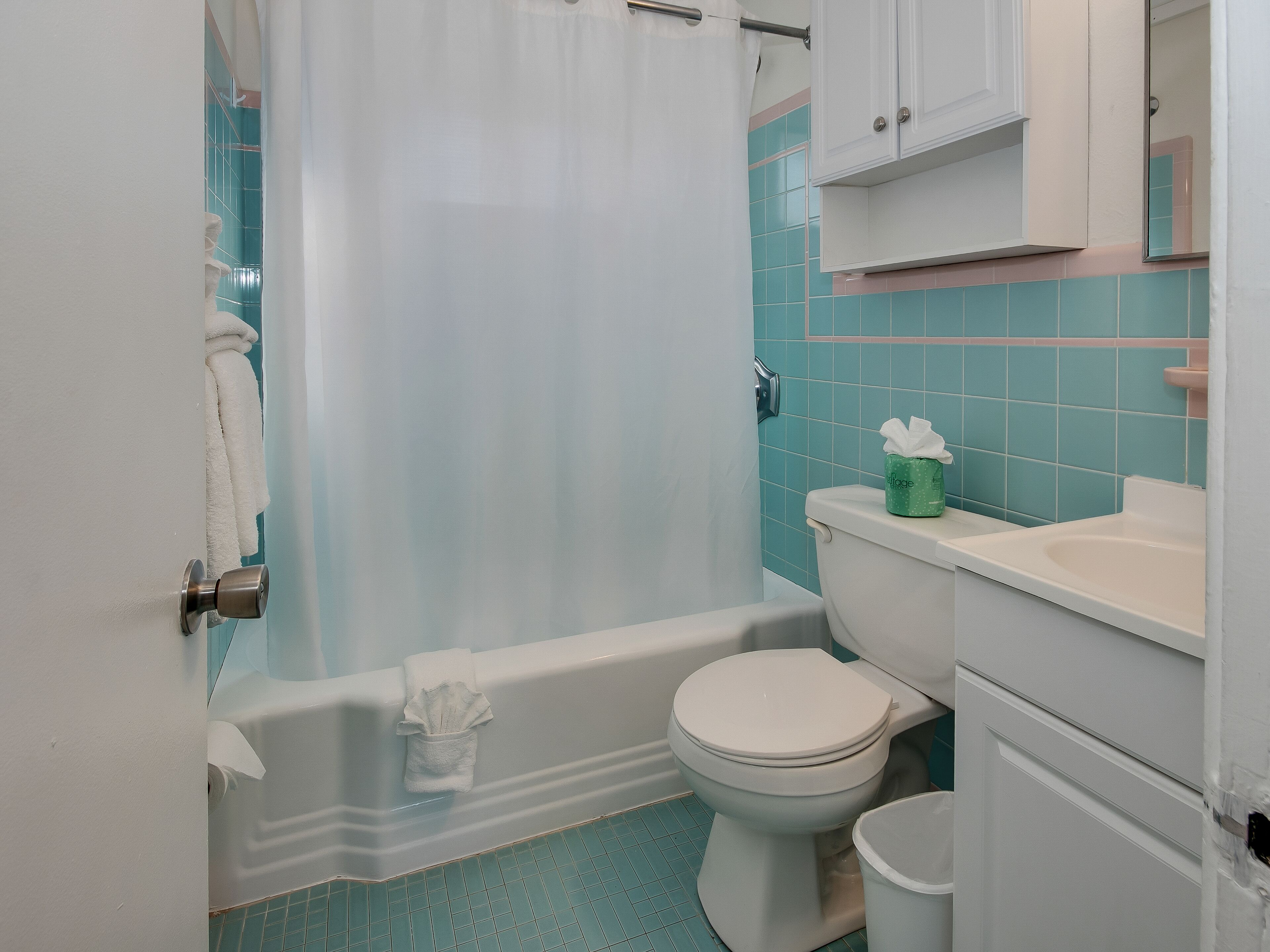A bathroom with a bathtub, toilet, and sink.
