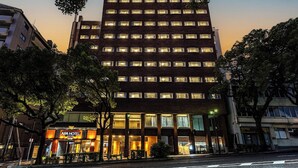 A multi-story hotel with a modern design, featuring a prominent entrance with a sign for the APA Hotel. - APA Hotel Nagasaki Dejima (Nagasaki)