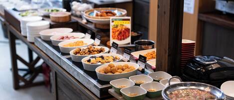 Un buffet proposant divers plats et différents types de mets présentés dans des plats ou des bols.