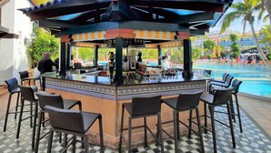 An outdoor bar area with a tiled floor, bar stools, and a pool in the background. - Park Club Europe - All Inclusive (Arona)