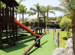 A playground with a slide, climbing structures, and a rope bridge. - Park Club Europe - All Inclusive (Arona)