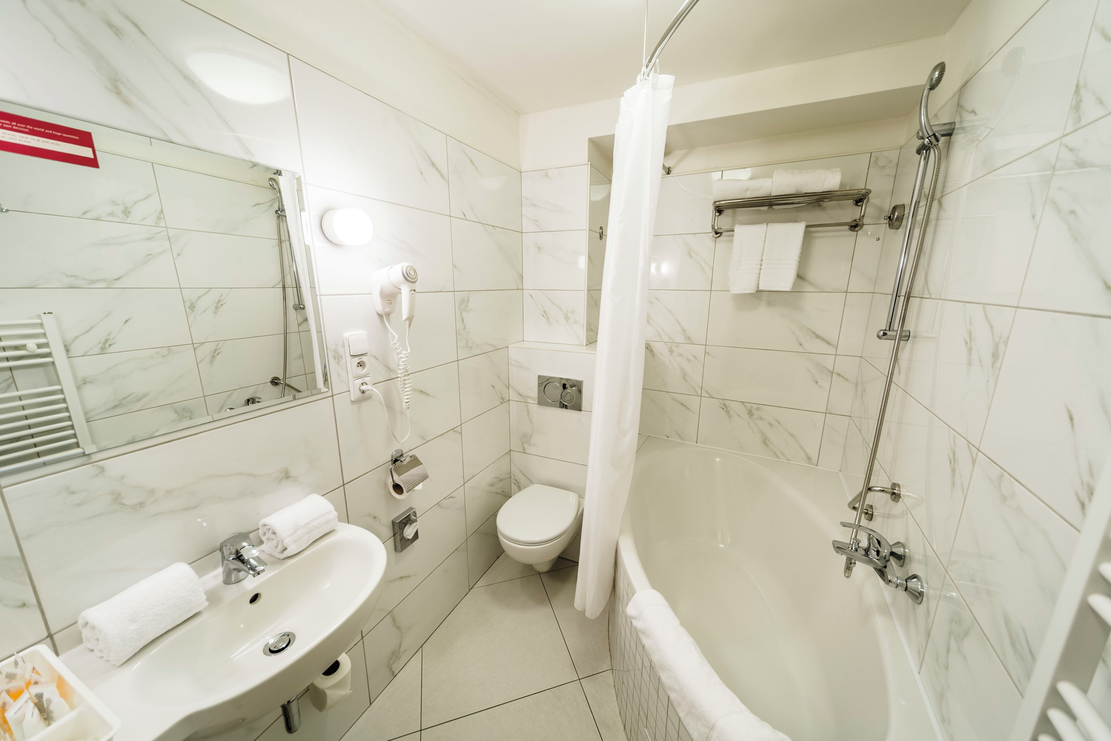 Un baño con lavamanos, inodoro y bañera.