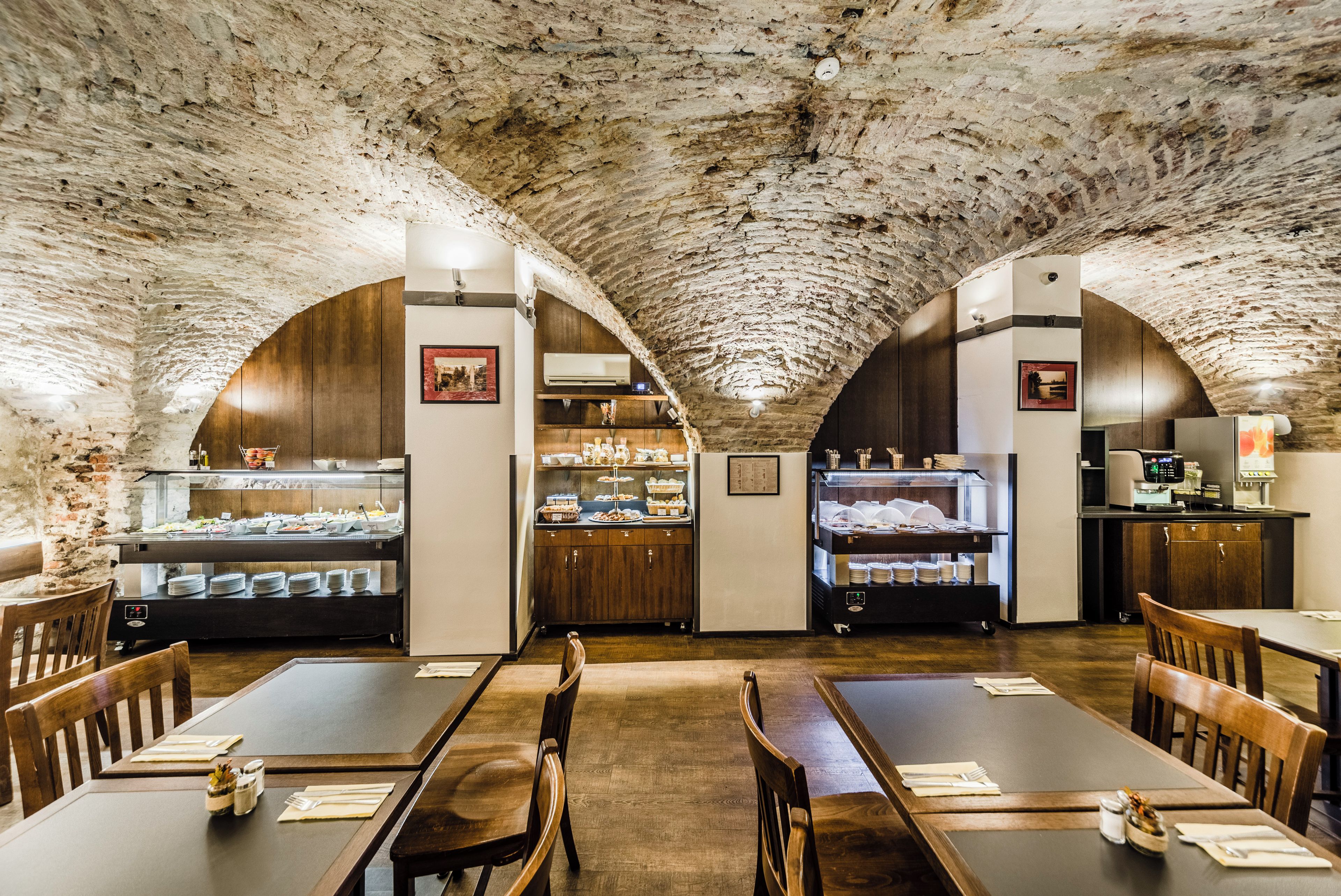 A restaurant with arched ceilings and wooden furniture.