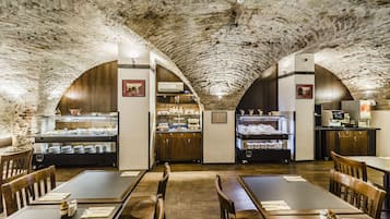 Un restaurant doté de voûtes en arc et de meubles en bois.