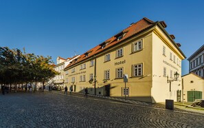 Ein historisches Gebäude mit einem Schild, das es als Hotel kennzeichnet, an einer Kopfsteinpflasterstraße.