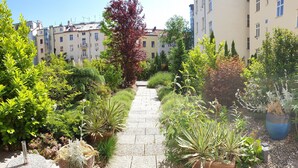 A garden pathway leading to a building with multiple windows and balconies. - Hotel Superior Prague (Prague)