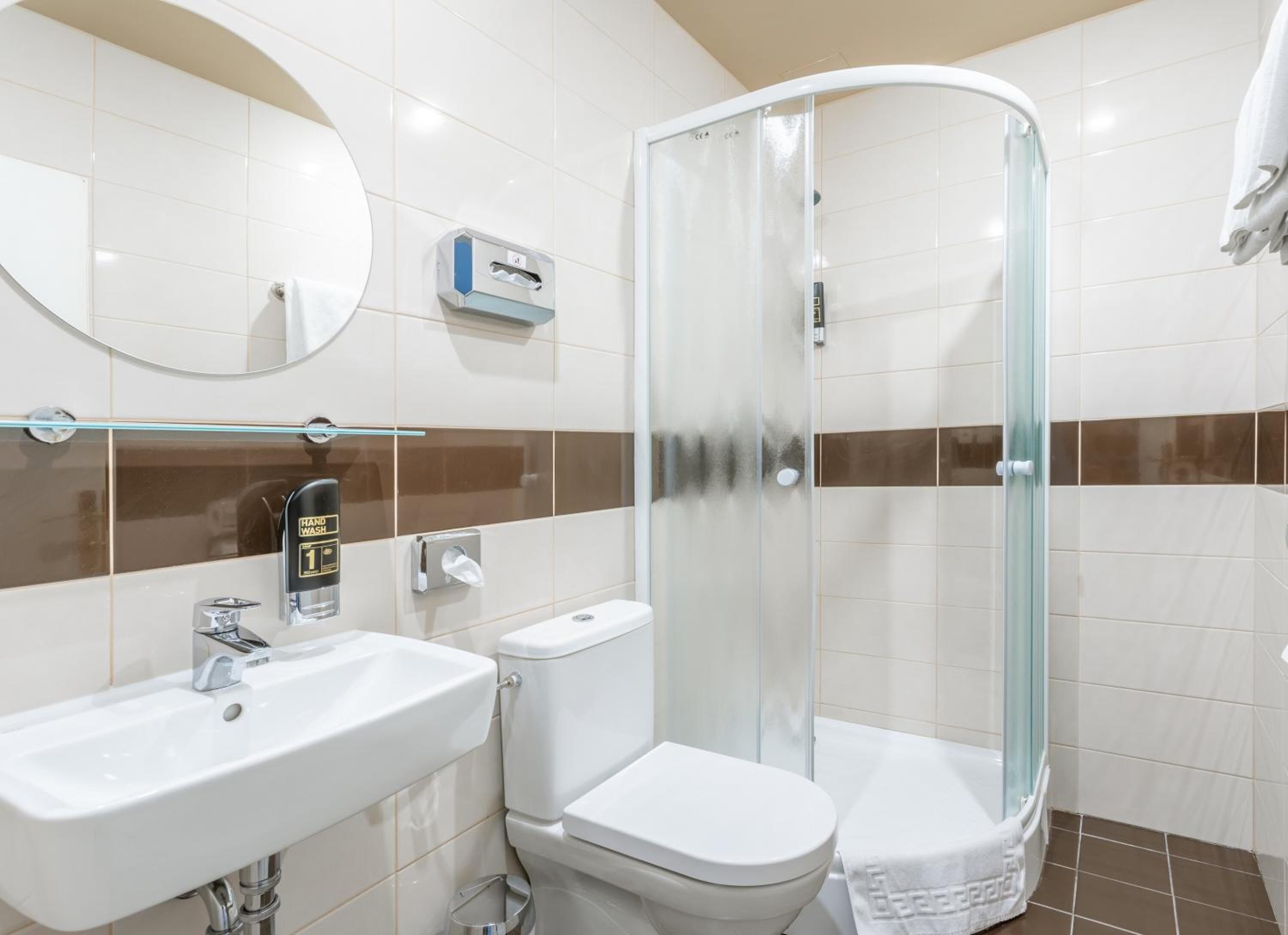 A modern bathroom with a sink, toilet, and glass-enclosed shower.