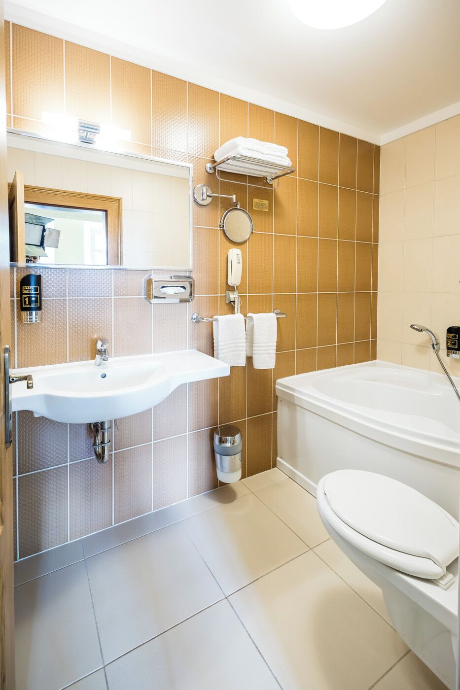 A bathroom with a sink, mirror, towel rack, and toilet.