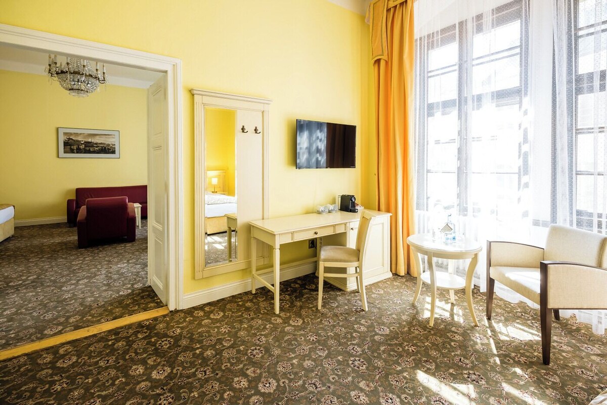 Een hotelkamer met een bureau, stoel en bed.