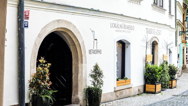 Un edificio histórico con una entrada en arco, un letrero que dice 'Metamorphis' y una calle empedrada.