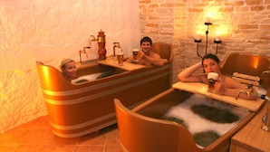 Two people in a bathtub with a wooden bench and a beer tap. - Hotel Metamorphis (Prague)