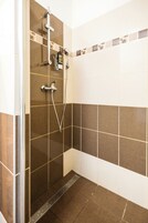 Een douche met een handdouche en een wandmengkraan.
