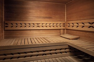 Uma sauna de madeira com bancos e design de piso inclinado.