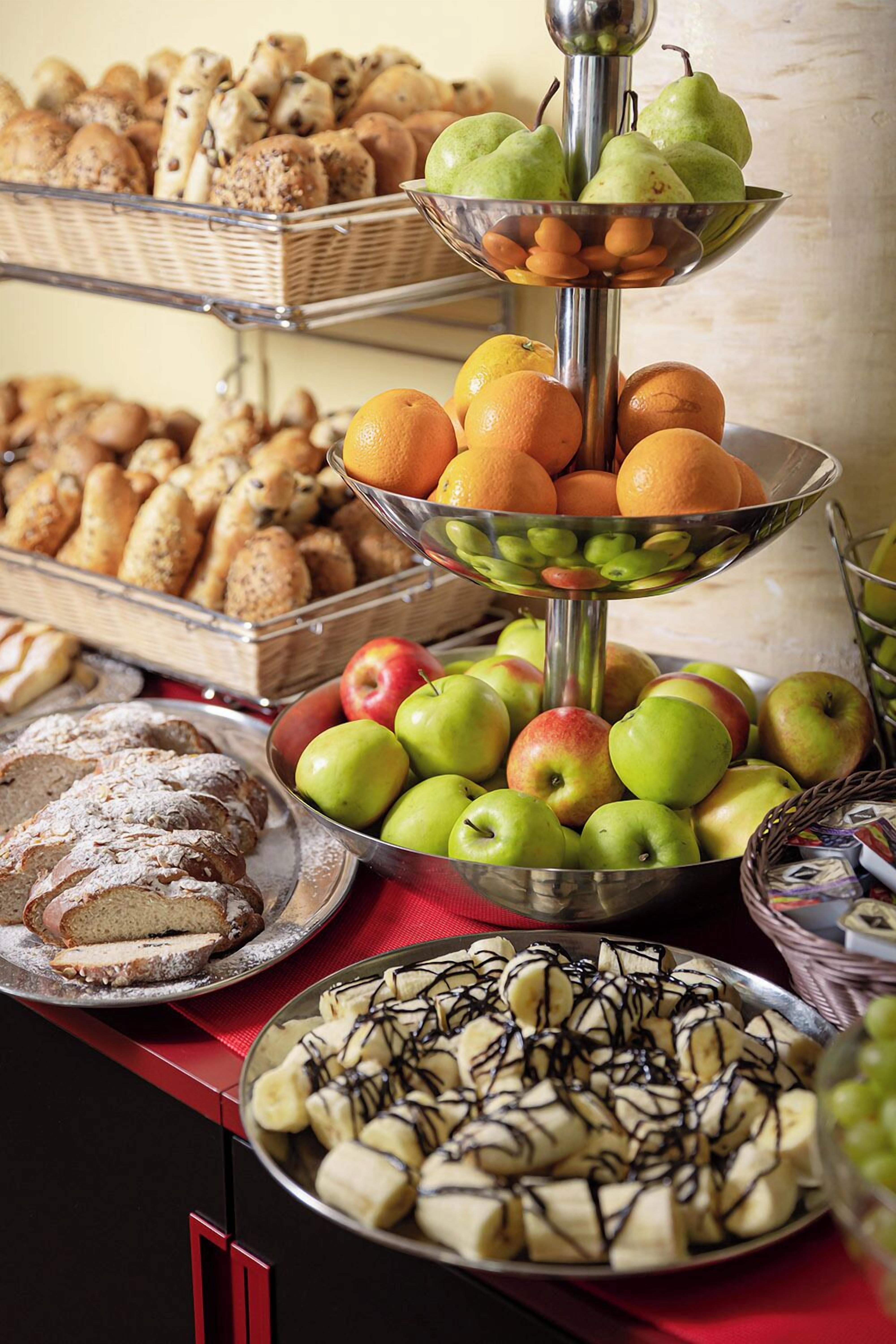 A buffet with various food items including fruits, pastries, and desserts.