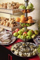 A buffet with various food items including fruits, pastries, and desserts.