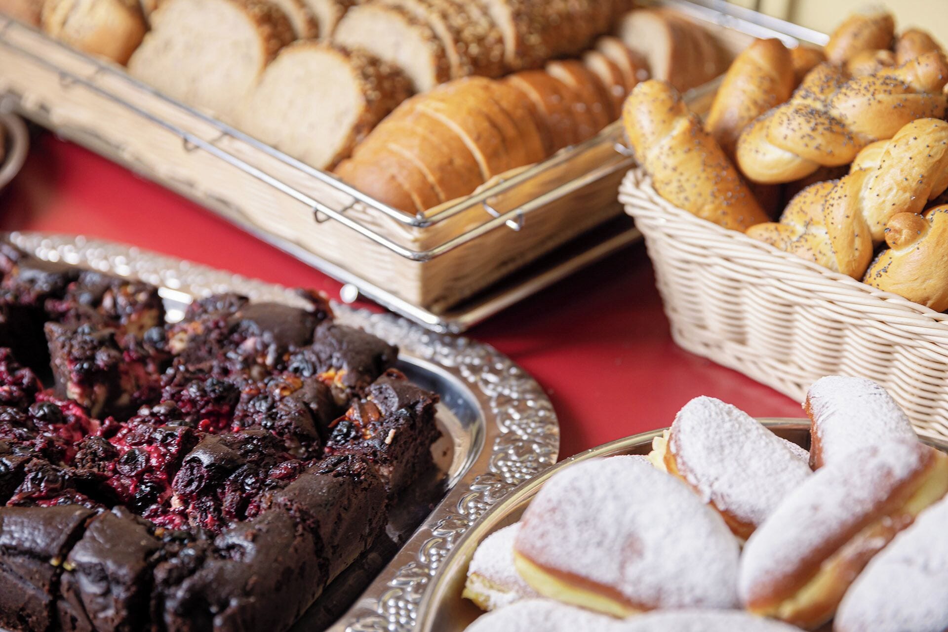 A variety of baked goods including bread, pastries, and a chocolate cake.