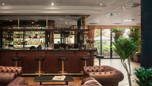 A bar area with a counter, stools, and a seating area with leather sofas. - Hotel Roma Prague (Prague)