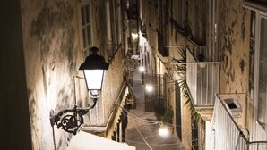 A narrow alleyway with buildings on either side, a street lamp, and string lights. - Aretusa Vacanze B&B (Syracuse)