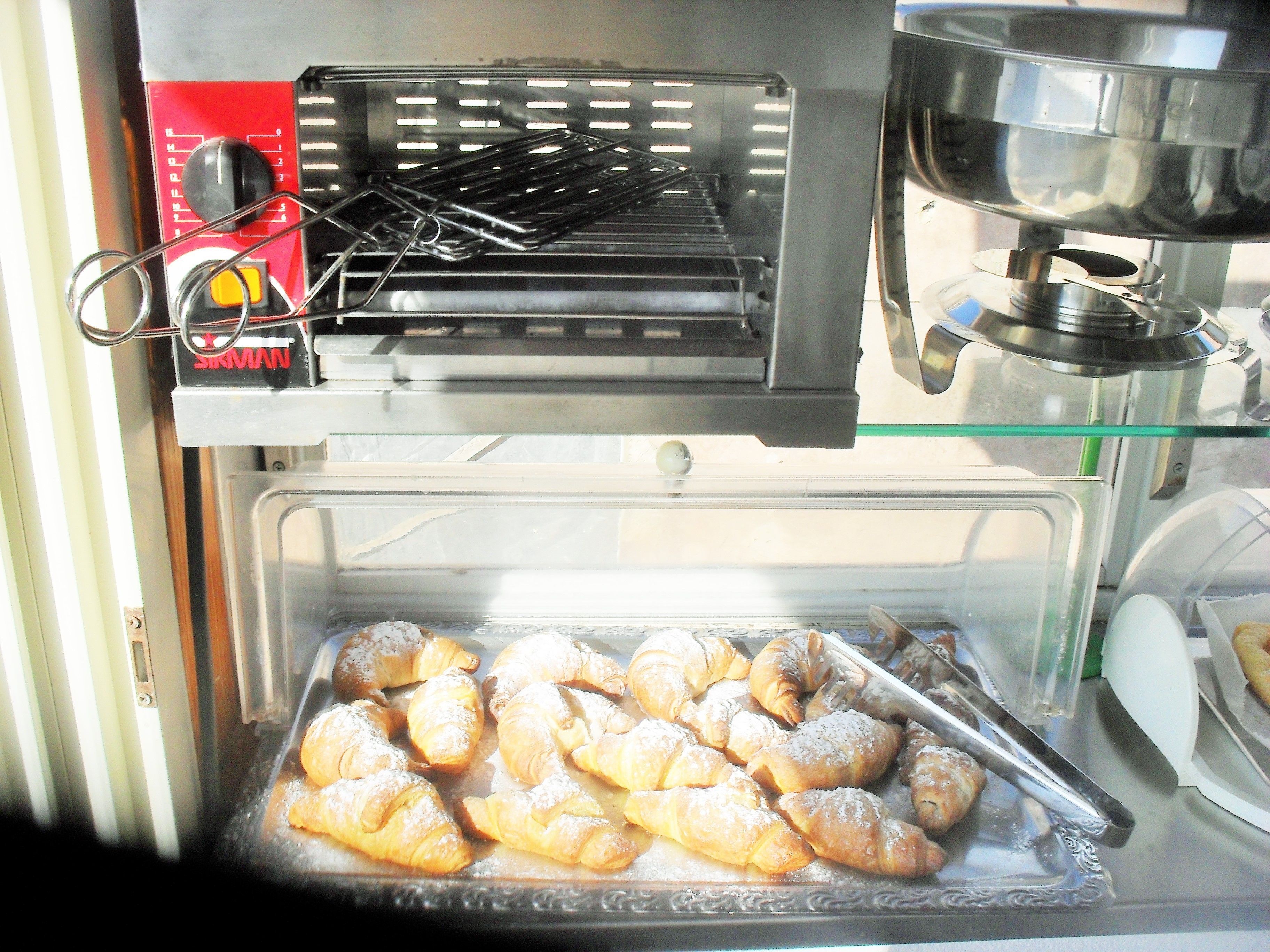 A bakery display with pastries and a coffee machine.
