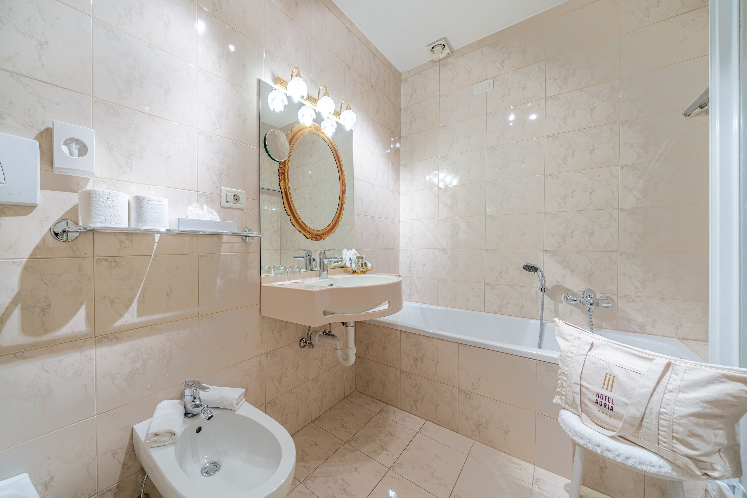 A modern bathroom with a sink, mirror, vanity, and bathtub.