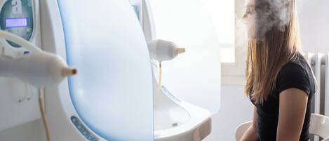 A person sitting in a chair next to a medical imaging machine.