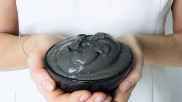 Una persona sosteniendo un recipiente negro con tapa.