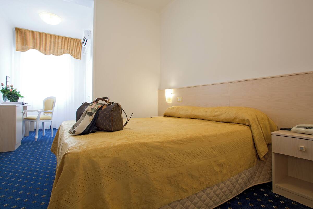 Une chambre d’hôtel comprenant un lit, une table de chevet, une chaise et un bureau.