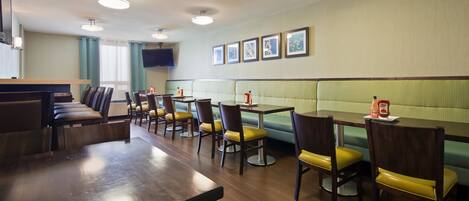 A restaurant with booths, tables, and chairs.