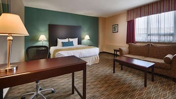 Habitación de hotel con una cama, un sofá, un escritorio y una silla.