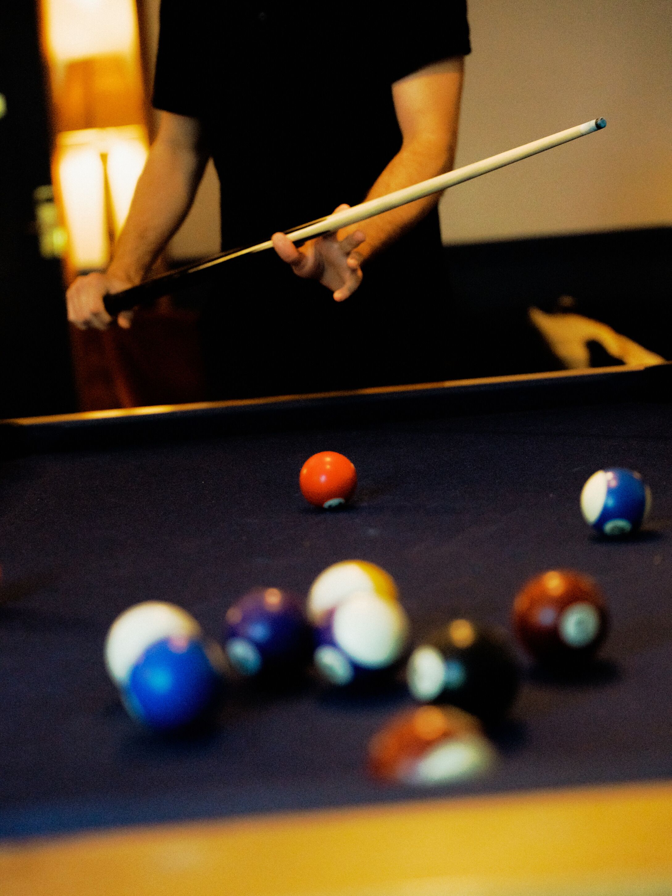 Une personne jouant au billard avec une queue.