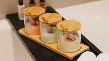 Three glass containers with wooden lids on a tray.