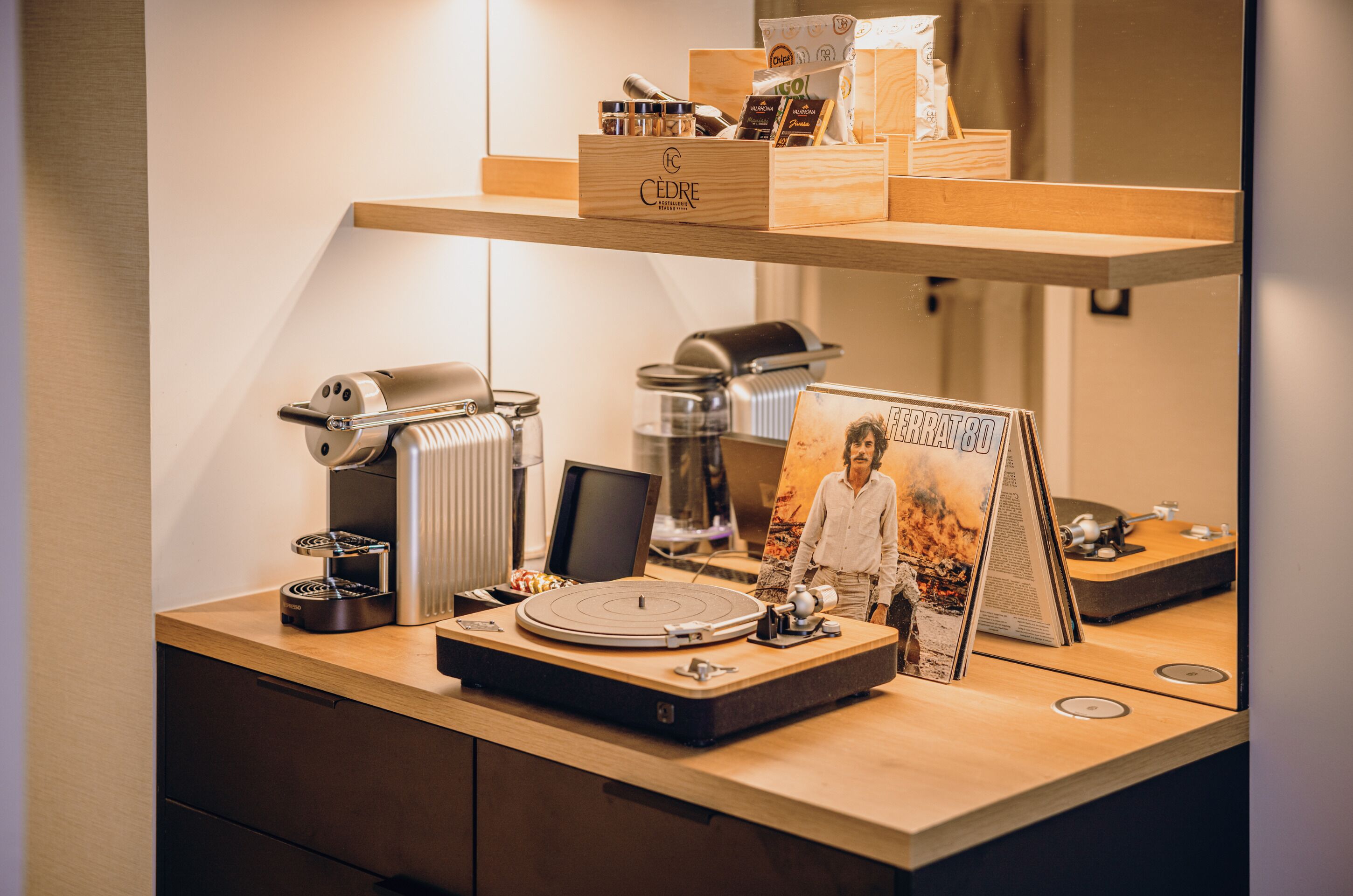 A wooden desk with a coffee machine, a vintage radio, and a framed picture.